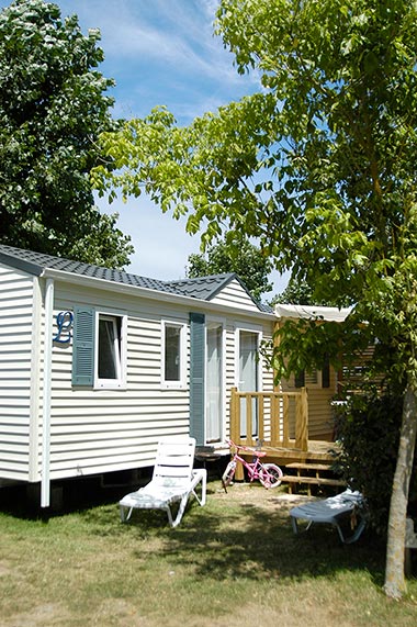 Location de mobil-home avec terrasse sous les arbres au camping à Saint-Hilaire-de-Riez