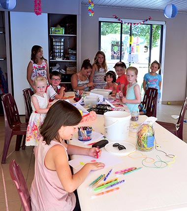 Kinder malen und zeichnen auf einem Tisch auf dem Campingplatz mit Kinderclub in der Vendée