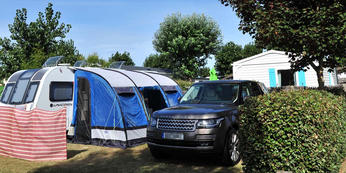 Car and caravan on a camping pitch at Les Écureuils campsite in Vendée at Saint-Hilaire-de-Riez