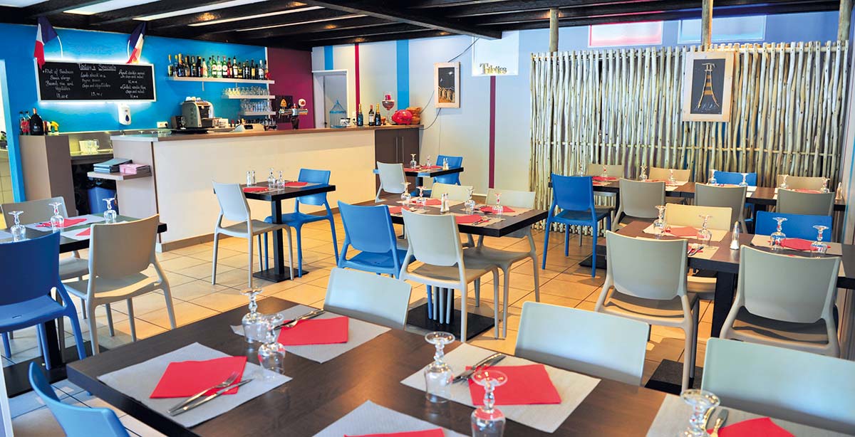 The interior of a restaurant with its tables in Vendée at Les Ecureuils campsite