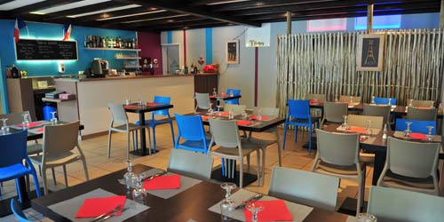 The interior of a restaurant with its tables in Vendée at Les Ecureuils campsite