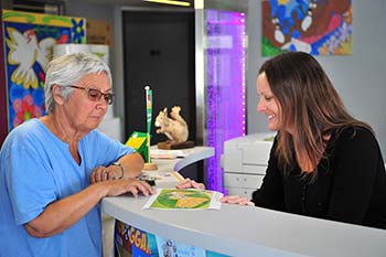 Klant en receptioniste bij de receptie van camping Les Écureuils in Vendée