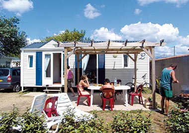 Family having lunch in front of their mobile home rental in Saint-Hilaire-de-Riez