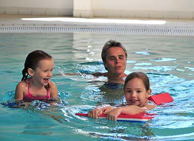 Famille avec enfants dans la piscine couverte du camping en Vendée