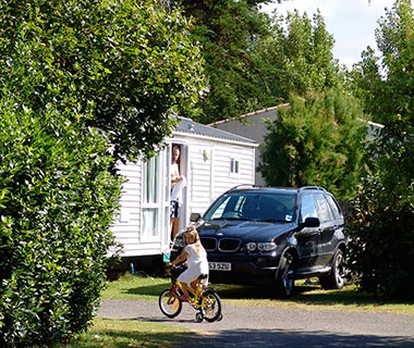 Klein meisje op de fiets voor een stacaravan in de buurt van Saint-Gilles-Croix-de-Vie