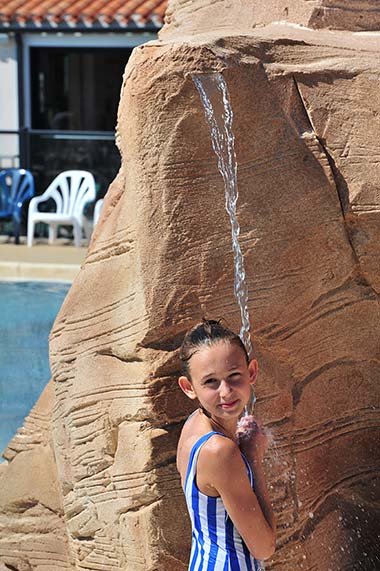 Girl under a fountain at the campsite in Saint-Hilaire-de-Riez in Vendée