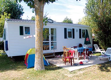 Terrasse avec table et parasol devant une location de mobil-home près de Saint-Jean-de-Monts