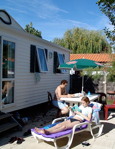 Familie op het terras van een stacaravan op de camping bij Saint-Jean-de-Monts