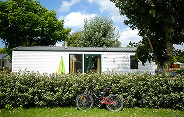Vélo devant la haie d'un emplacement de mobil-home au camping proche de Saint-Gilles-Croix-de-Vie