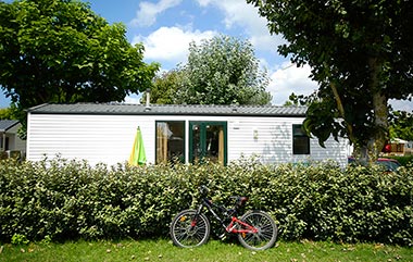 Fiets voor de heg van een stacaravan op de camping bij Saint-Gilles-Croix-de-Vie