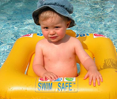 Child with a buoy in the paddling pool at Les Écureuils campsite near Saint-Jean-de-Monts