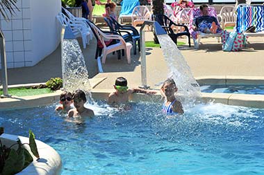 Kinderen onder waterstralen masseren in het zwembad van de camping in Saint-Hilaire-de-Riez