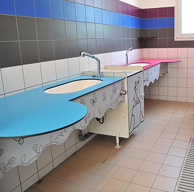 Washbasins in the children's corner of a sanitary block at Les Écureuils campsite in Vendée