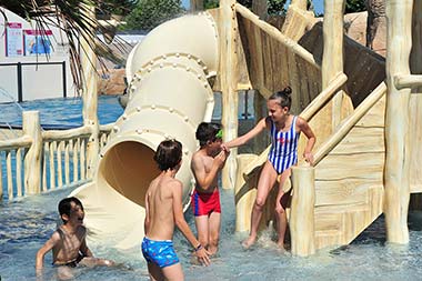 Children in front of a water play structure at Les Écureuils campsite in Vendée