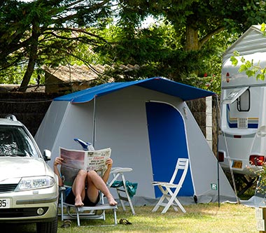 Camper reading his newspaper on a deckchair on his campsite near Saint-Jean-de-Monts