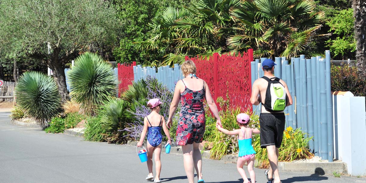 Family in an alley of Les Écureuils campsite near Saint-Jean-de-Monts