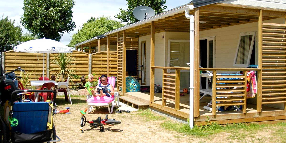 Terrasse en bois couverte d'un mobil-home dans le parc du camping à Saint-Hilaire-de-Riez