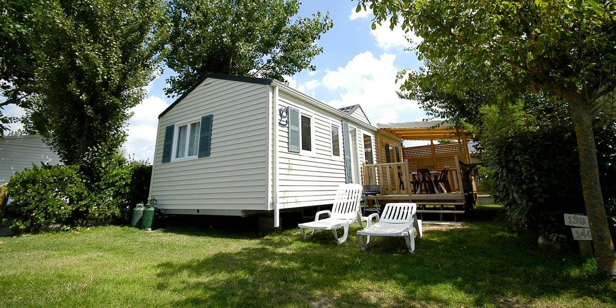 Deckchairs in front of a mobile home for rent at Les Écureuils campsite in Vendée