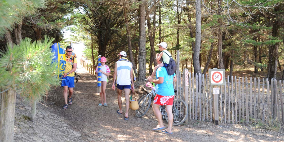 Campeurs accédant au bord de mer proche du camping Les Écureuils en Vendée