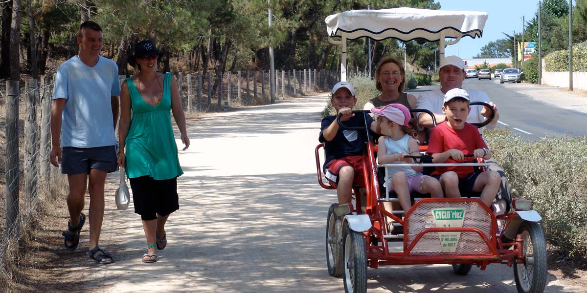 Familie von Campern, die auf einem Radweg in der Nähe des Campingplatzes in Saint-Hilaire-de-Riez eine Rosalie gemietet haben