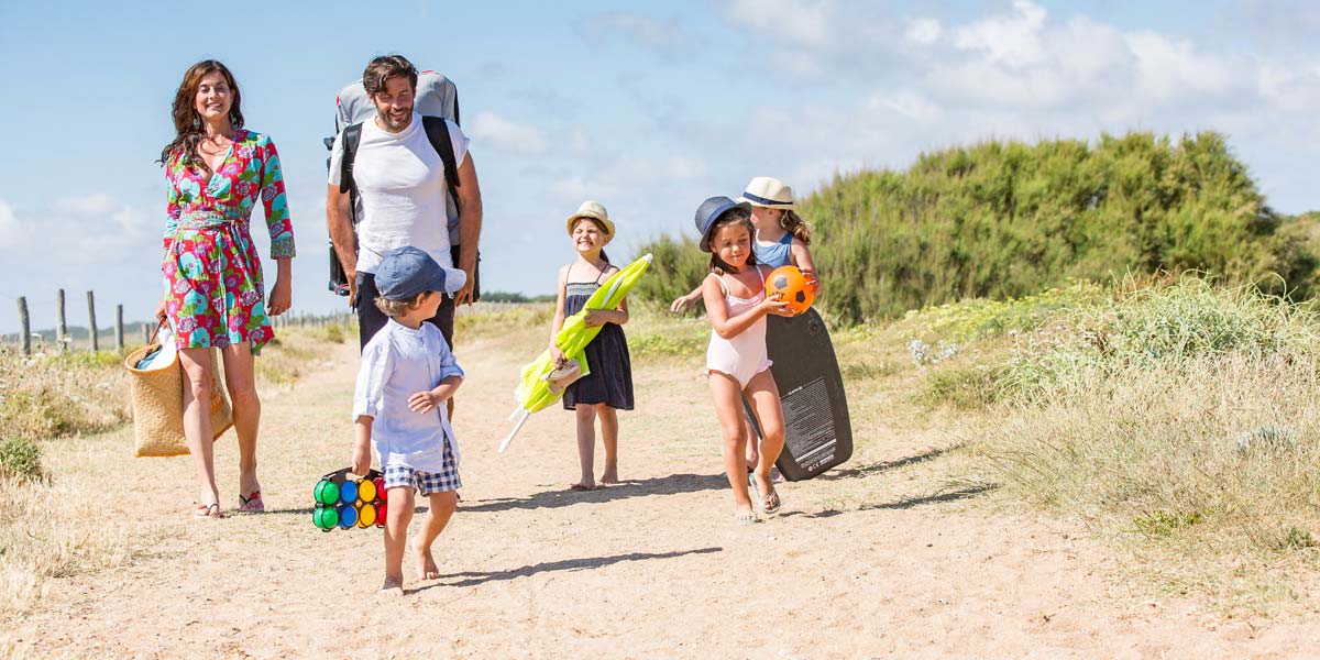 Familie auf einem Weg durch die Düne zum Meer in Saint-Hilaire-de-Riez